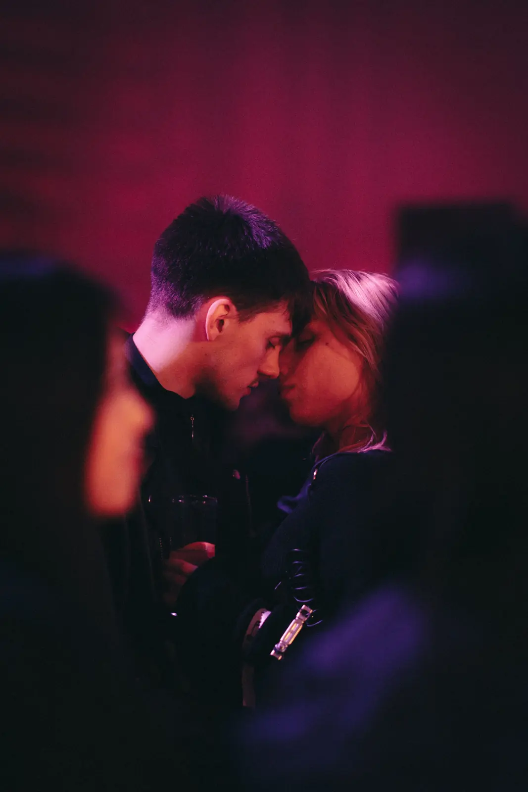 Illustrative stock image of an adult couple embracing in a dark nightclub