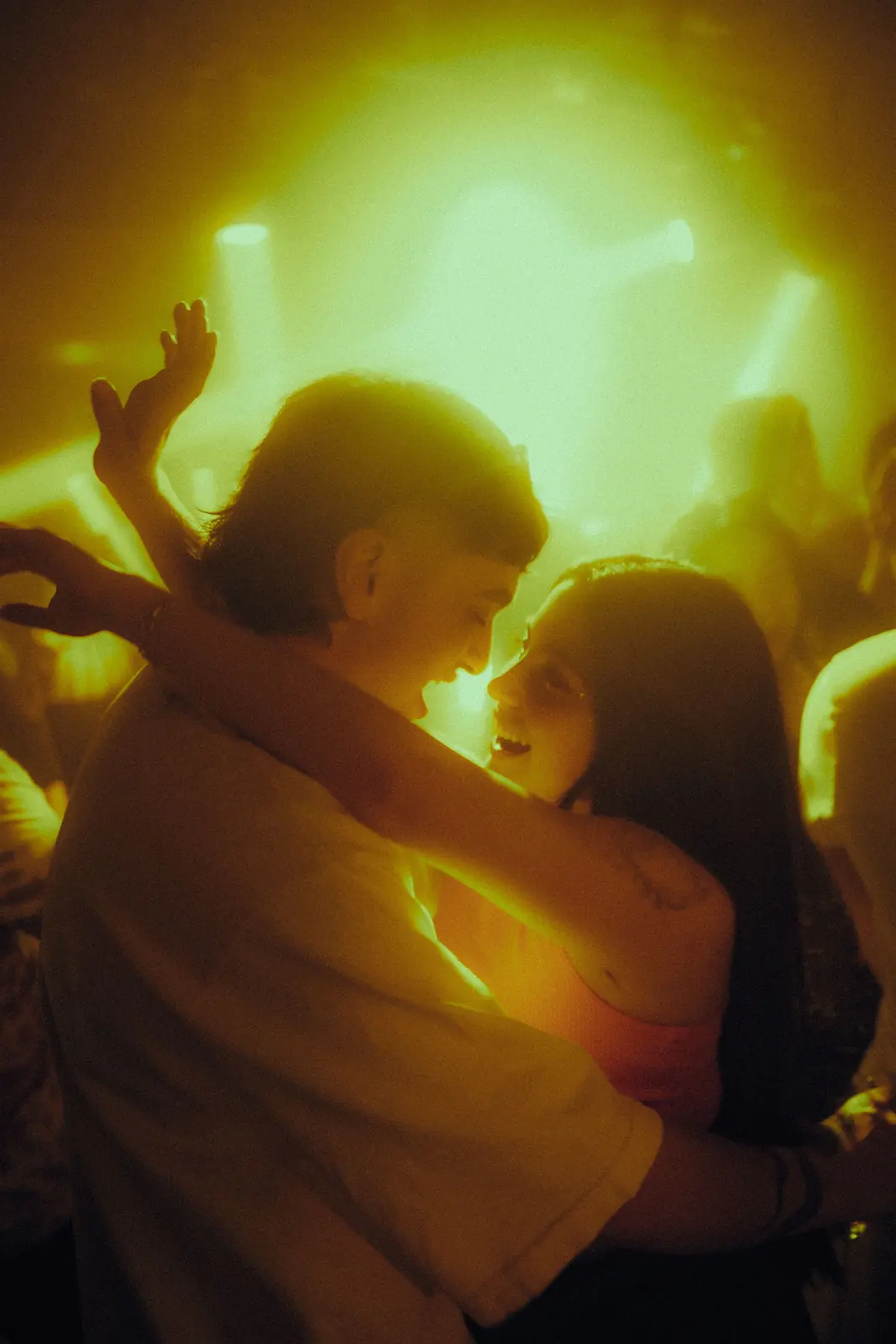 Illustrative stock image of an adult couple kissing in a nightclub crowd