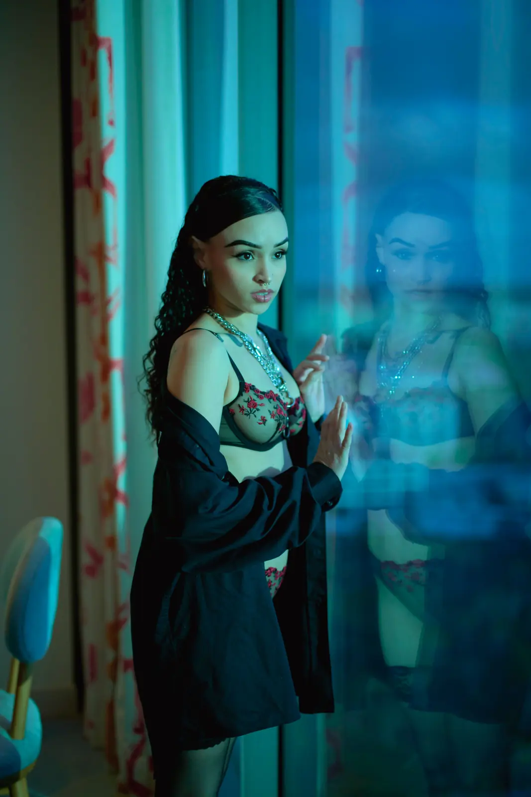 Illustrative stock image of an adult woman by a window in a nightlife setting